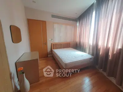 Cozy bedroom with wooden flooring and natural light