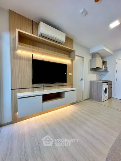 Modern living room with sleek TV unit and integrated washing machine in open layout.