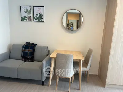 Cozy living room with modern decor, featuring a stylish sofa, dining table, and wall art for a welcoming ambiance.