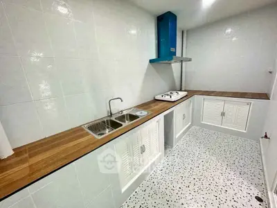 Modern kitchen with sleek countertops and gas stove in a stylish real estate property.