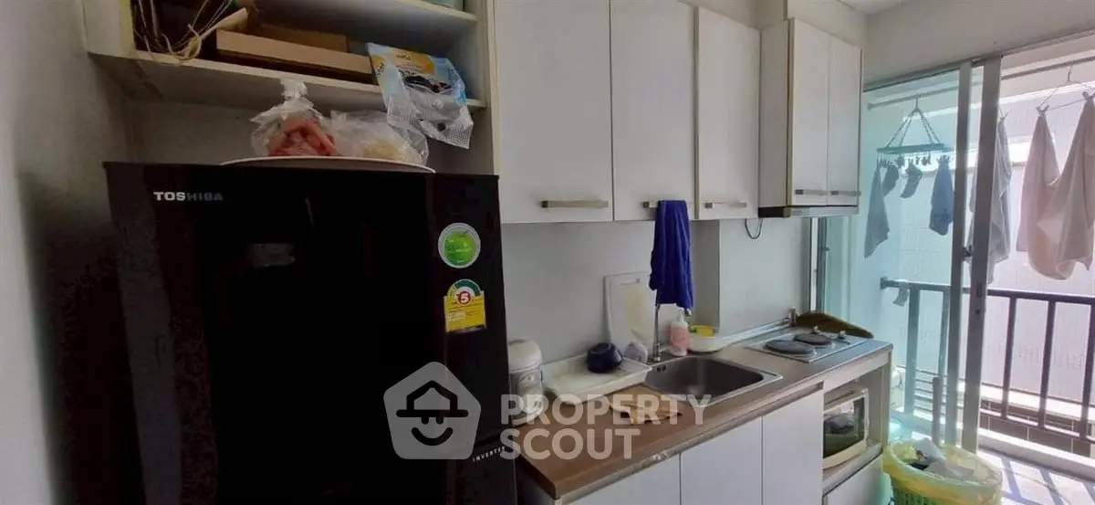 Compact kitchen with balcony access in modern apartment