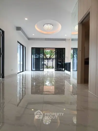 Spacious modern living room with glossy marble floors and elegant lighting, featuring large windows and garden view.