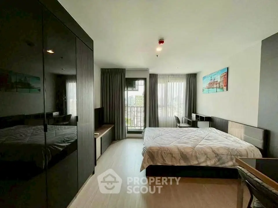 Modern bedroom with large windows and city view, featuring sleek furniture and stylish decor.