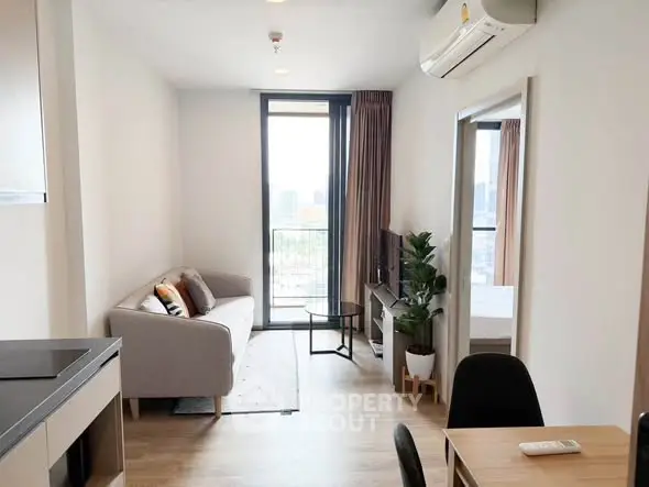 Modern living room with city view, featuring sleek furniture and natural light.