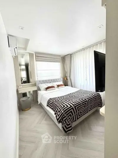 Modern bedroom with stylish decor and large windows for natural light.