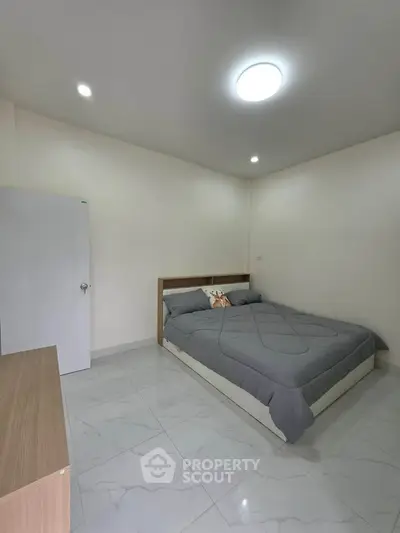 Spacious bedroom with modern decor and cozy ambiance