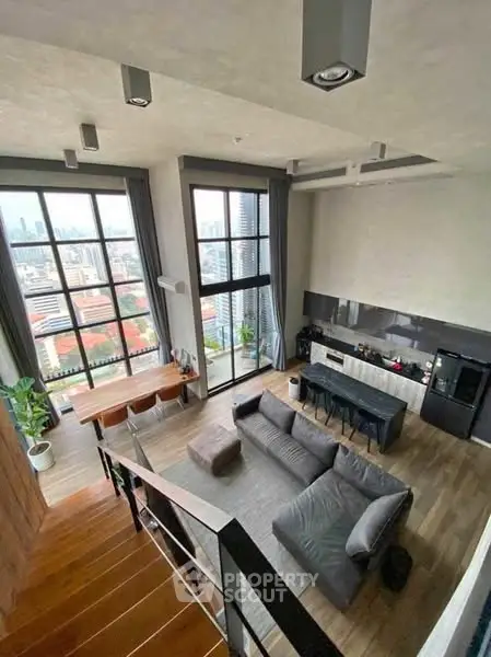 Stunning loft apartment with high ceilings and panoramic city views, featuring modern kitchen and spacious living area.