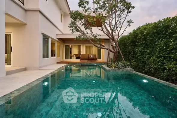 Luxurious modern home with stunning private pool and lush greenery, perfect for relaxation and entertainment.