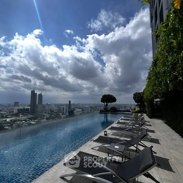 Luxurious rooftop pool with stunning city skyline view and modern lounge chairs.