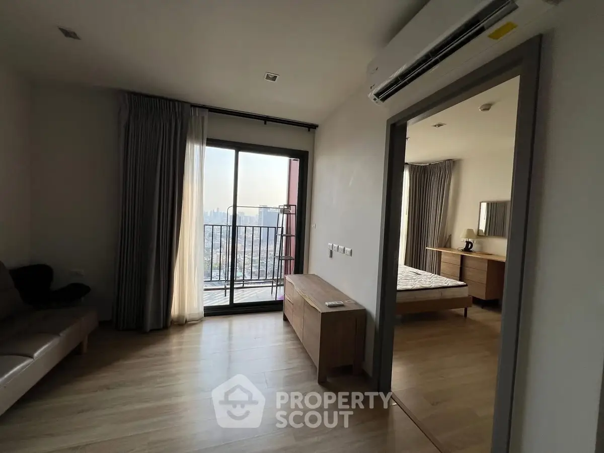 Modern apartment with balcony and city view, featuring sleek interior design and natural light.
