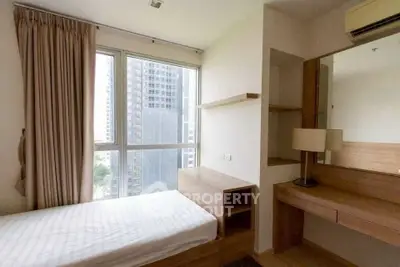 Modern bedroom with city view, featuring minimalist furniture and large windows.