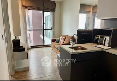 Modern living room with open kitchen and large windows in a stylish apartment.