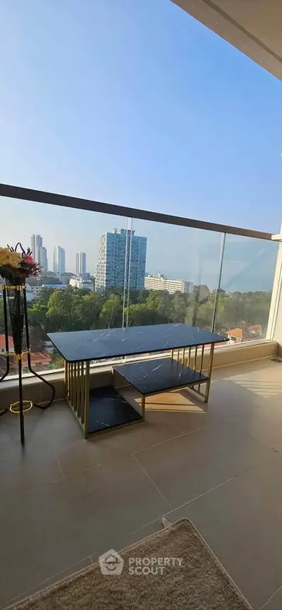Spacious balcony with stunning cityscape view and modern glass railing.