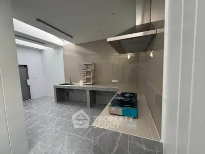 Modern kitchen with sleek gas stove and open layout, featuring elegant tile flooring and ample counter space.