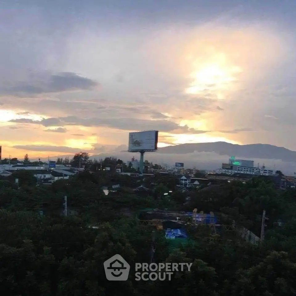 Stunning sunset view over a cityscape with mountains in the background.