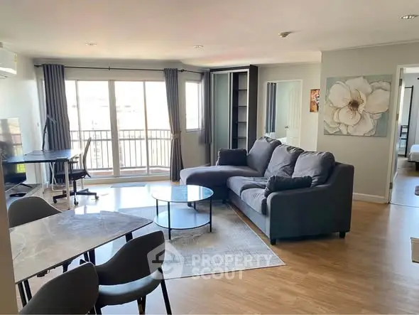 Spacious modern living room with large windows and stylish furniture in a bright apartment.