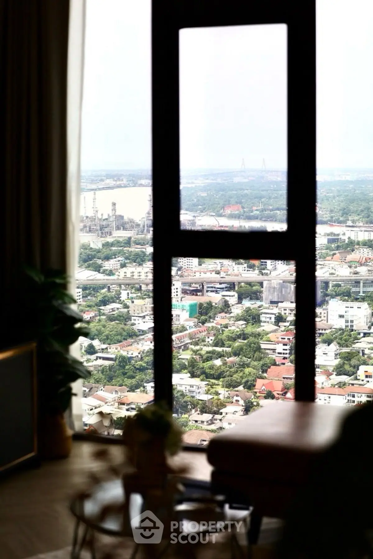 Stunning high-rise apartment view overlooking cityscape and river, offering breathtaking panoramic scenery.