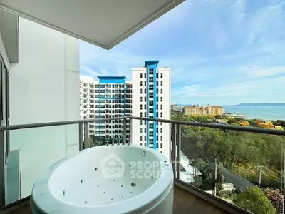 Stunning balcony with jacuzzi and ocean view in modern high-rise building.