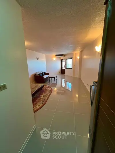 Spacious living room with modern tile flooring and cozy seating area.