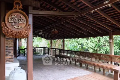 Charming wooden terrace with traditional decor and lush garden view.