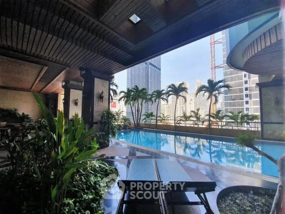Luxurious rooftop pool with stunning city skyline views and lush greenery.