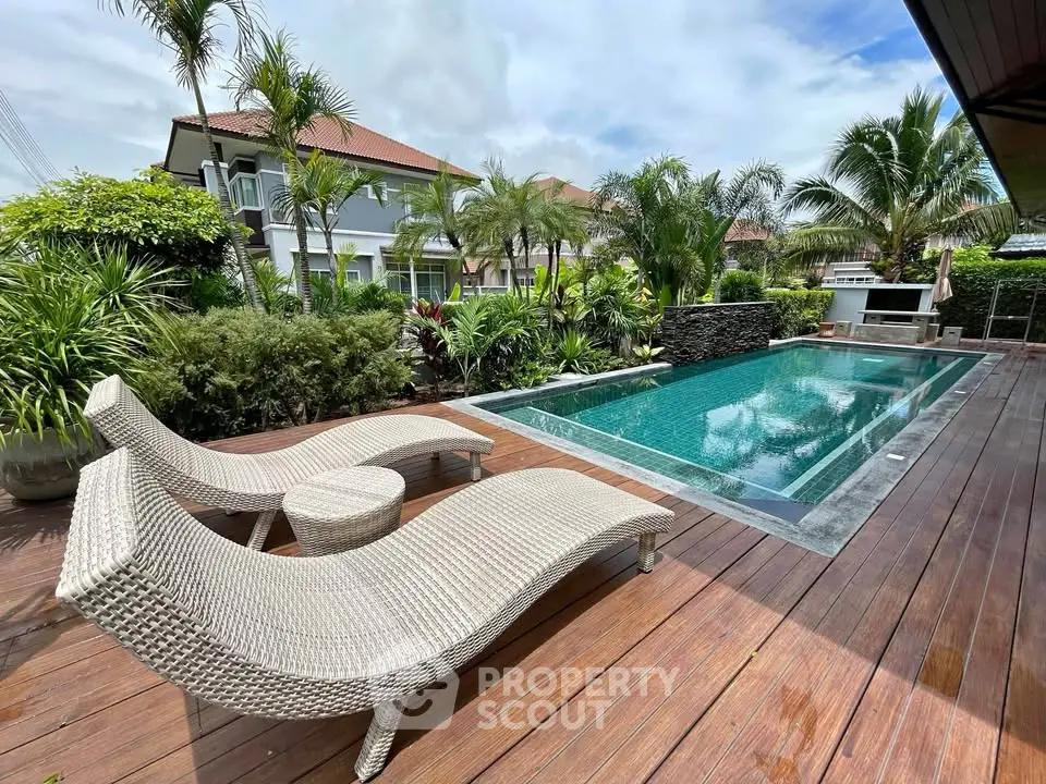 Luxurious backyard with a sparkling pool and stylish lounge chairs, perfect for relaxation.