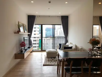 Modern living room with city view, featuring stylish furniture and natural light.