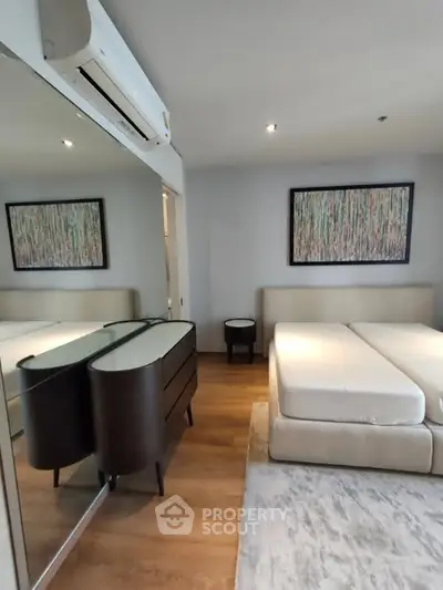 Modern bedroom with stylish decor and mirrored wardrobe in a contemporary apartment.
