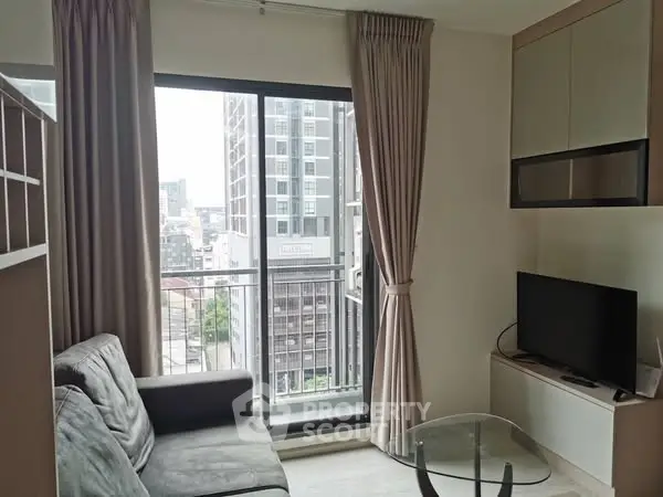 Modern living room with city view, featuring a cozy sofa and sleek TV setup.