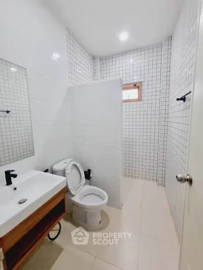 Modern bathroom with sleek fixtures and tiled walls in a contemporary home.