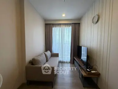 Cozy living room with modern sofa and TV, featuring floor-to-ceiling window for natural light.