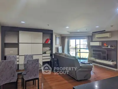 Spacious living room with modern furniture and large windows offering city views.