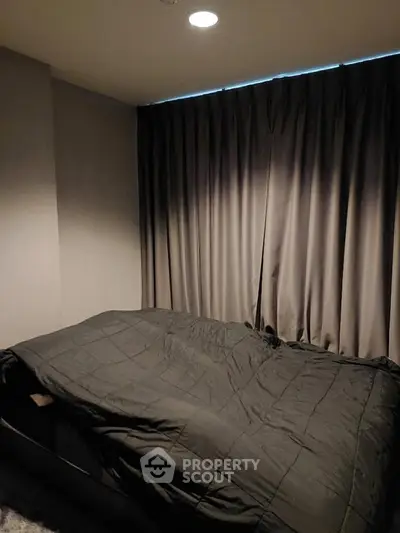 Cozy bedroom with dark curtains and modern bedding