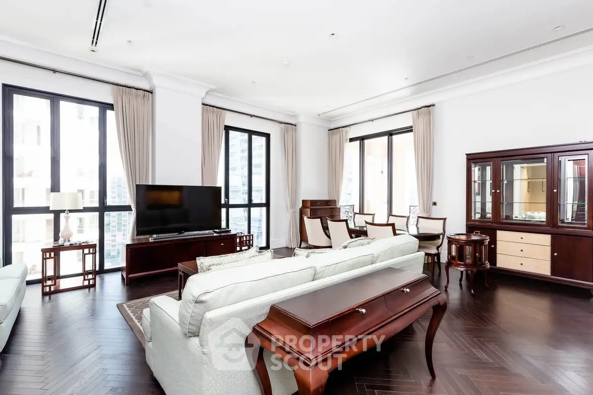 Spacious and elegant living room with classic furniture and large windows in a luxury apartment.