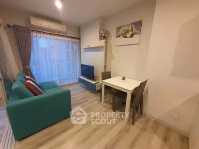 Cozy living room with teal sofa, dining table, and modern decor in a bright apartment.