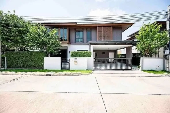 Modern two-story house with lush greenery and spacious driveway