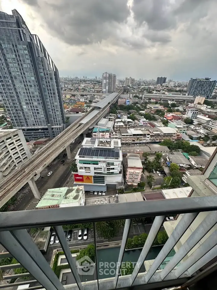 Stunning cityscape view from high-rise balcony overlooking urban skyline and transit lines.