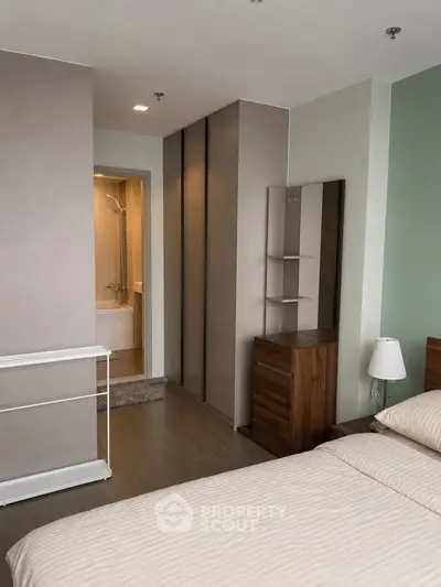 Modern bedroom with ensuite bathroom and stylish furniture in a contemporary apartment.
