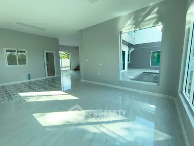 Spacious modern living room with large windows and glossy tiled floors