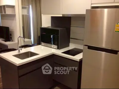 Modern kitchen with sleek appliances and stylish cabinetry in a contemporary apartment.