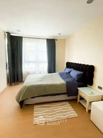 Cozy bedroom with modern decor and natural light, featuring a comfortable bed and stylish curtains.