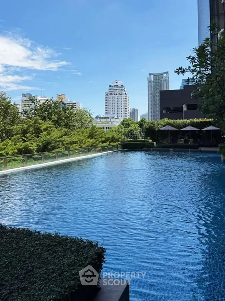 Luxurious rooftop pool with stunning cityscape views and lush greenery, perfect for relaxation and leisure.