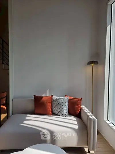 Stylish modern living room with cozy sofa and floor lamp by large window