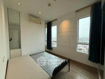 Spacious bedroom with large windows and city view, featuring modern design and natural light.
