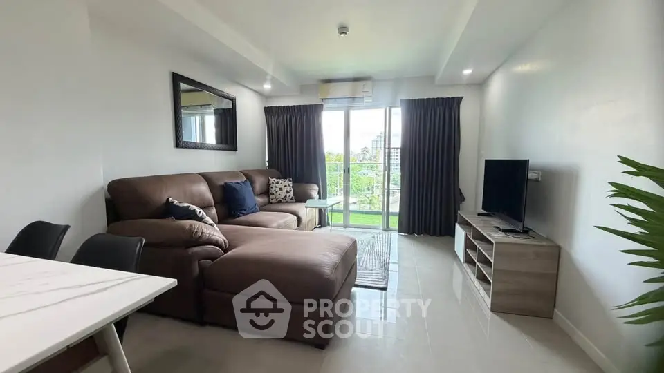Spacious living room with modern furniture and large windows offering a scenic view.