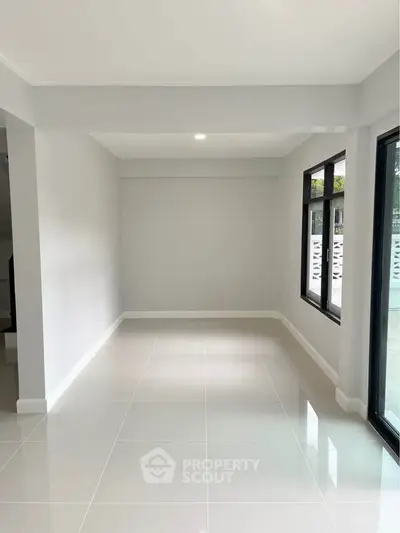 Spacious and bright interior with large windows and glossy tiled floors