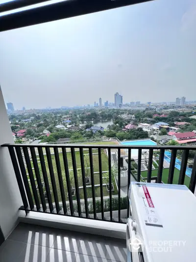 Spacious balcony with panoramic city and park views, offering a serene outdoor retreat in a high-rise apartment.