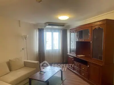 Cozy living room with elegant wooden cabinet and comfortable seating, perfect for relaxation.