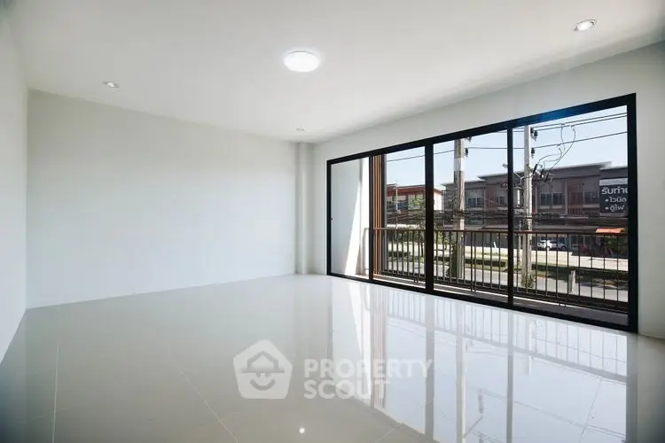 Spacious empty living room with large windows and balcony view