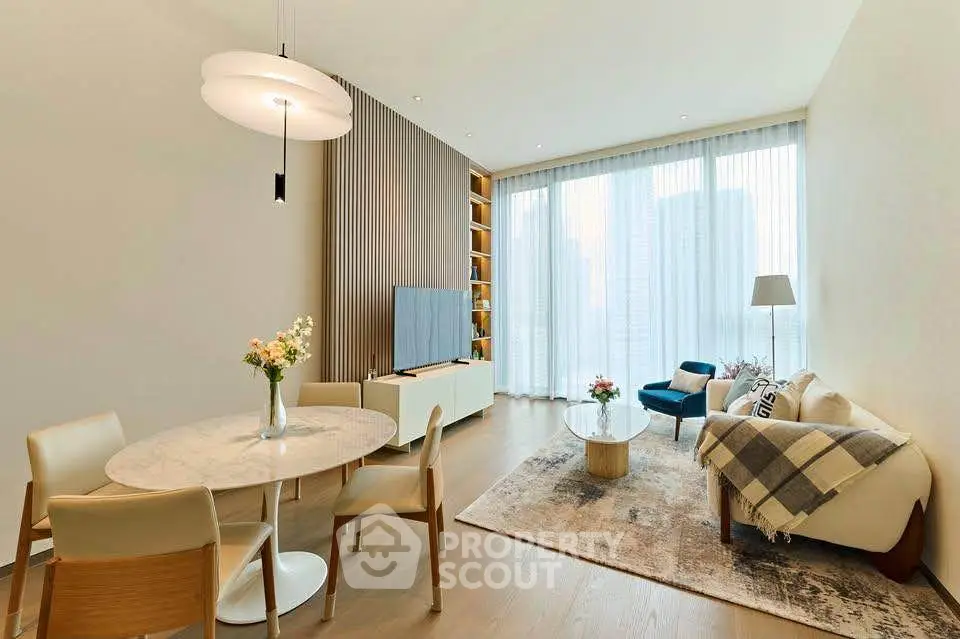 Modern living room with elegant decor, large windows, and stylish furniture.